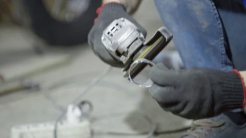 Labor worker sanding pieces of pipe with angle grinder machine Stock Footage 128919183