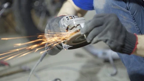 Labor worker sanding pieces of pipe with angle grinder machine Stock Footage 128919444
