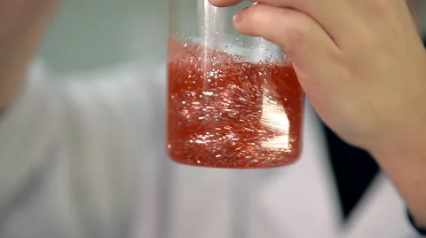The laboratorian is mixing the ingredients in a glass Vidéo 59109192