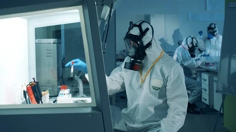 Laboratory analysis is being done by an expert in a hazmat suit Stock Footage 129391554