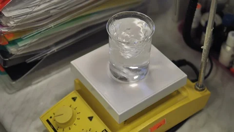 Laboratory assistant adds blue reagent to a clear liquid. Stock Footage 128456061