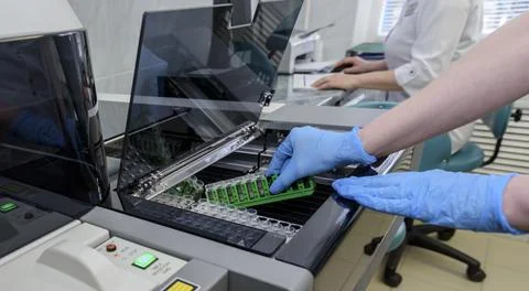 Laboratory assistant is analyzing fluid, gloved hand Stock Photos