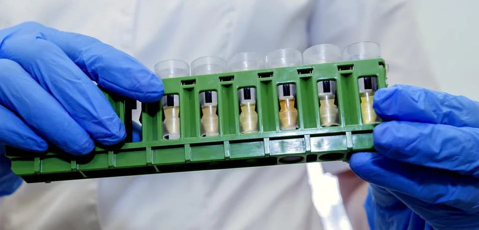 Laboratory assistant is analyzing fluid, gloved hand Stock Photos