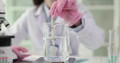 Laboratory assistant checks water sample with test strip Stock Footage 301072083