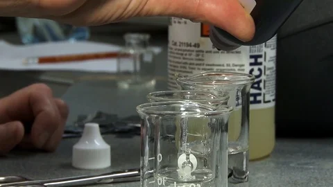 Laboratory assistant detects a red liquid in a transparent liquid. Stock Footage 127321270