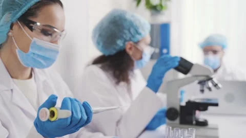 Laboratory assistant examines the liquid in the container Stock Footage 230459895