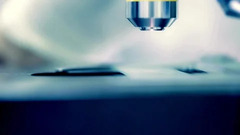A laboratory assistant investigates protein structures under a microscope. Stock Footage 336583214