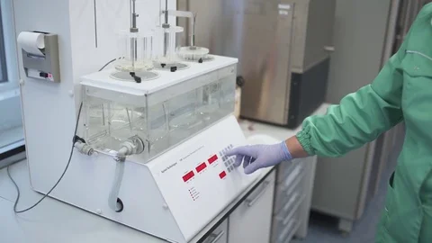Laboratory assistant manages the medical machine for mixes liquid substance. Stock Footage 84371286