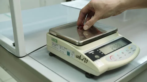 Laboratory assistant measures weight of sample of product Stock Footage 231221233