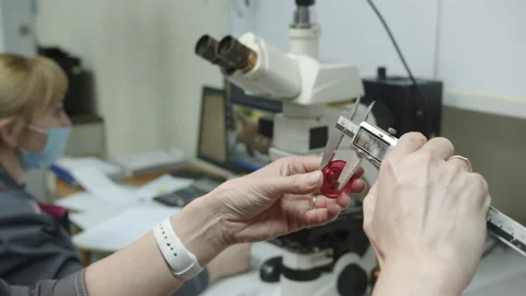 Laboratory assistant measures width of washer using caliper Stock Footage 230037771