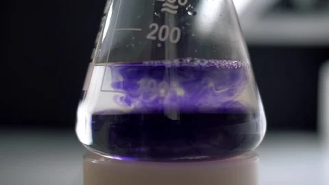 Laboratory assistant mixes reagents in a test tube flask for analysis Stock Footage 128583639