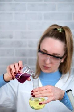 The laboratory assistant mixes two substances in a flask. Conducting chemical Stock Photos