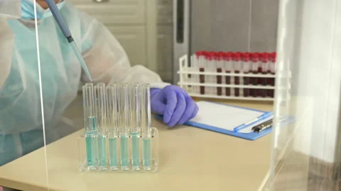 Laboratory assistant pipetting the reagent into a test tube with blood. Stock Footage 129756720