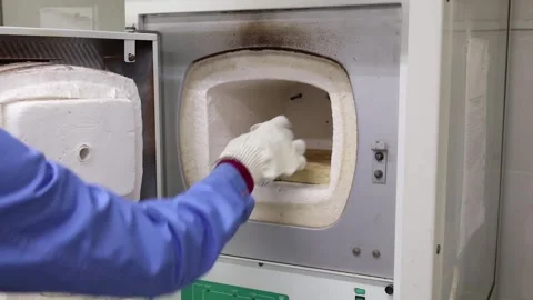 The laboratory assistant puts a test tube with the substance in a thermostat Stock Footage 340517020