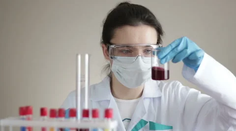 Laboratory assistant shakes flasks Stock Footage 66257008