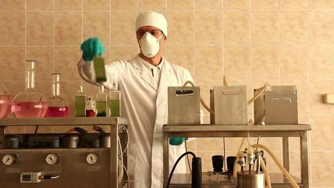 Laboratory assistant shakes microalgae culture filled flask Stock Footage 78527383