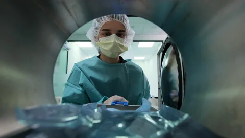 Laboratory assistant takes out packaging with dental tools from autoclave 動画素材 131883644