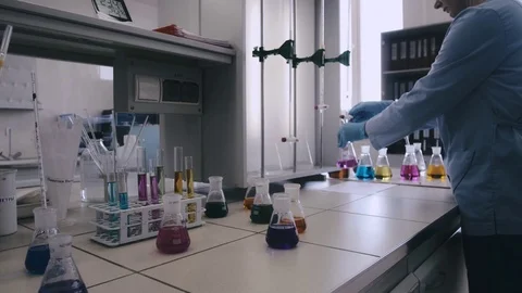 Laboratory beaker in analyst's hand in plastic glove. Stock Footage 76739694