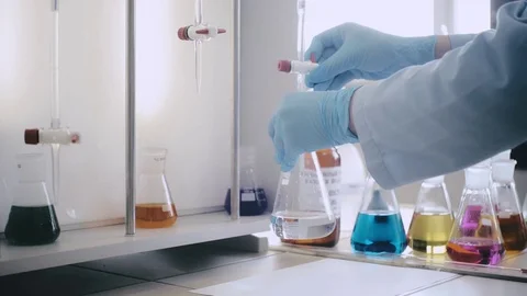 Laboratory beaker in analyst's hand in plastic glove. Video stock 76739734