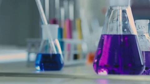 Laboratory beaker in analyst's hand in plastic glove. Stockbeeldmateriaal 76740669