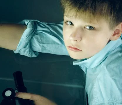Laboratory. a boy and  microscope. close-up. top view Stock Photos