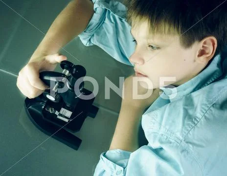 Laboratory. a boy and microscope. close-up. top view Stock Photos