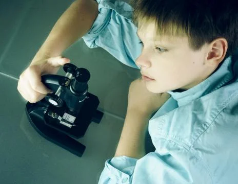 Laboratory. a boy and microscope. close-up. top view Stock Photos