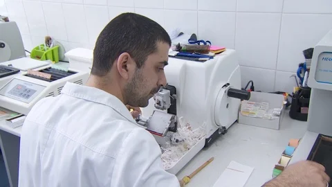 A laboratory employee performs a biopsy. cuts the tumor with a very sharp knife. Stock Footage 113686085
