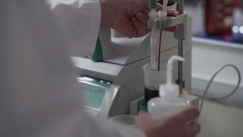 Laboratory expert removes measuring cup with liquid and starts testing 库存影片 130356733