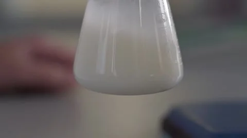 Laboratory expert shakes up the liquid in the flask extreme close up 库存影片 130356740