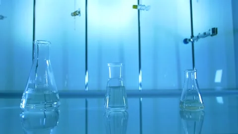 Laboratory Flasks in blue on a table Stock Footage 240690284
