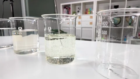 Laboratory Glass Beakers with Liquid on White Table Stock Footage 346595564