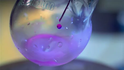 Laboratory glass bottle mixing two chemicals in slow motion Stock Footage 257030320
