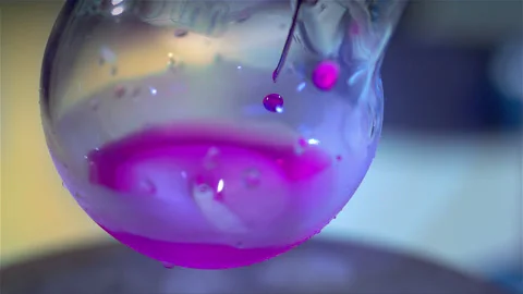 Laboratory glass bottle mixing two chemicals in slow motion Stock Footage 257030353