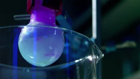 Laboratory glass bottle mixing two chemicals in slow motion Stock Footage 257032898