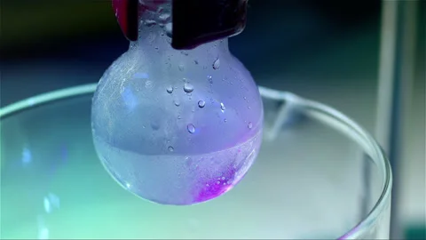 Laboratory glass bottle mixing two chemicals in slow motion Stock Footage 257033755