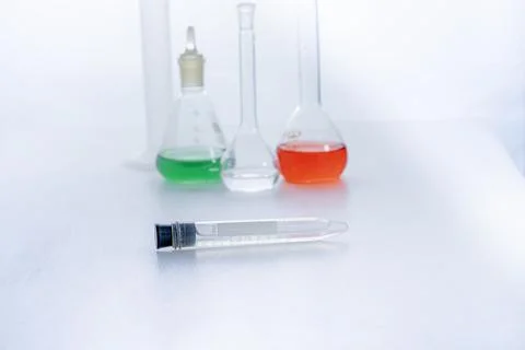 Laboratory glass flasks with multicolored liquid isolated on white Stock Photos