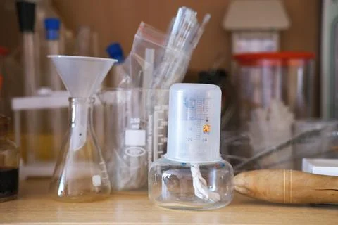Laboratory glassware including beakers, flasks, and measuring tools arranged on Stock Photos