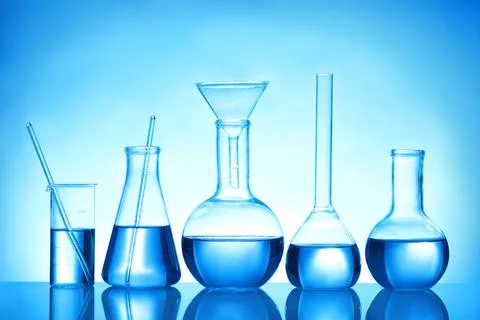 Laboratory glassware with liquid samples for analysis on blue background Stock Photos