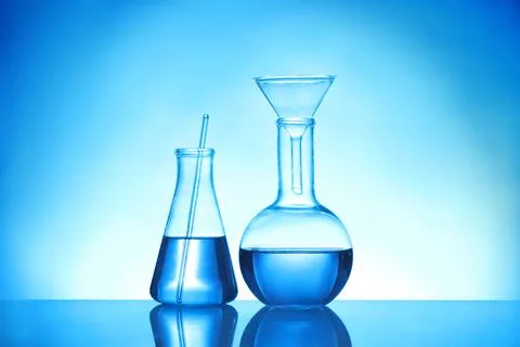 Laboratory glassware with liquid samples for analysis on blue background Stock Photos