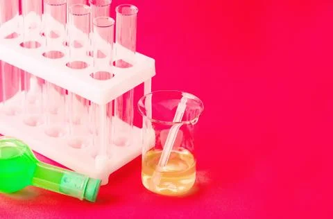 Laboratory glassware on red background. Stock Photos