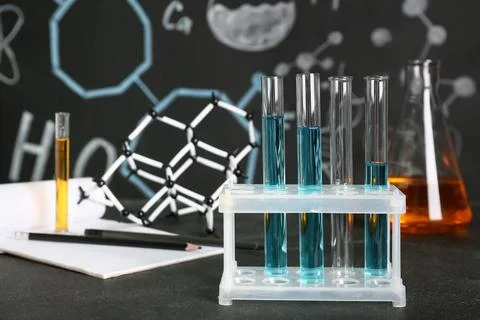 Laboratory glassware of samples with notebook and molecular model on table ag Stock Photos
