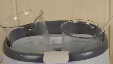Laboratory glassware in a water bath preparing a pharmaceutical emulsion for Stock Footage 335183048