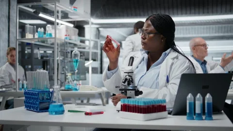 Laboratory histology technician evaluating pharmaceutical compound in petri dish Stock Footage 327100152