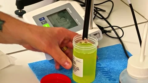 Laboratory instrument measuring green liquid sample quality during scientific Stock Footage 333725908