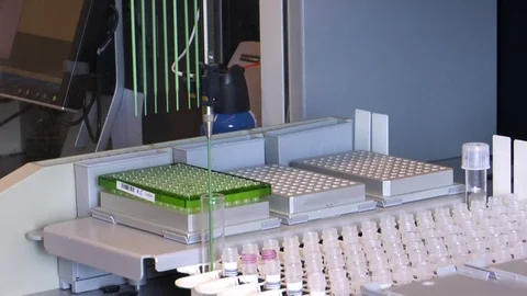 Laboratory machines inputting samples into well plates Stock Footage 99049996