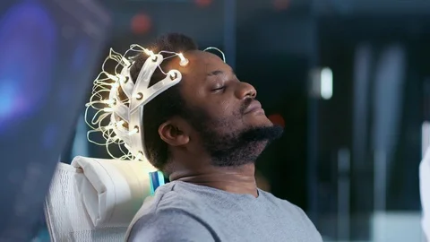 In Laboratory Man Wearing Brainwave Scanning Headset Sits in a Chair Stock Footage