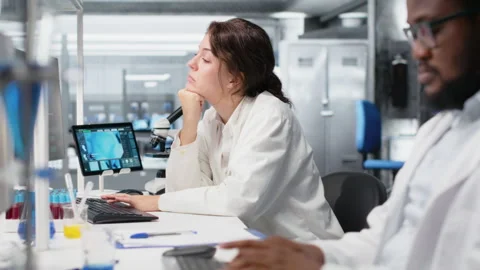 Laboratory manager oversees scientists working on computer Stock Footage 320143577