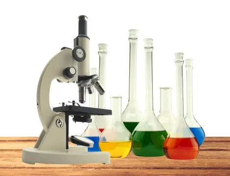 Laboratory metal microscope and test tubes with liquid on wooden table isolat Stock Photos