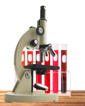 Laboratory metal microscope and test tubes with blood in holder on wooden tab Stock Photos